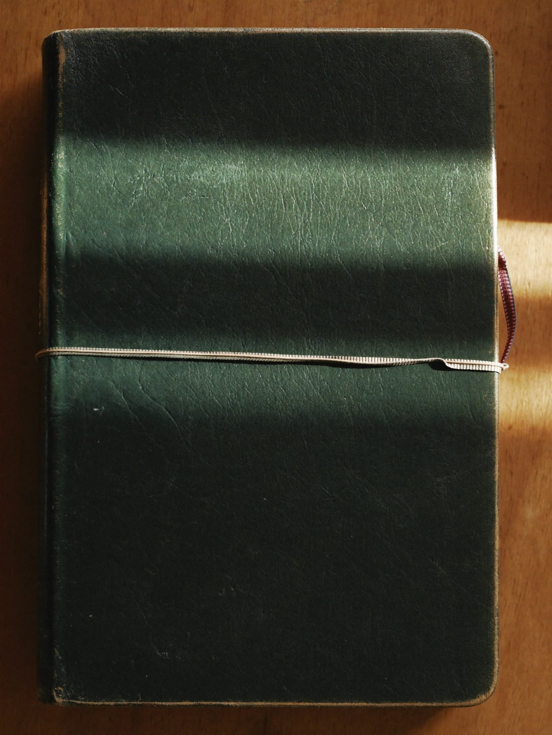Grüne Lederbibel im warmen Fensterlicht